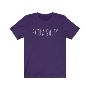 May include: A purple short-sleeved t-shirt with the text "EXTRA SALTY" printed in white on the front.