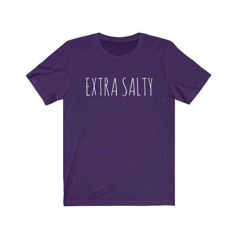 May include: A purple short-sleeved t-shirt with the text "EXTRA SALTY" printed in white on the front.