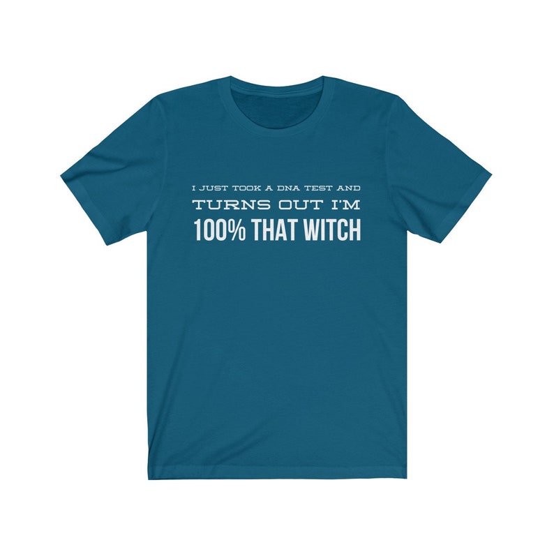 May include: A teal short-sleeve t-shirt featuring white text printed on the chest that reads: I JUST TOOK A DNA TEST AND TURNS OUT I'M 100% THAT WITCH. The shirt has a crew neckline and a standard fit, providing a clear view of the graphic design.