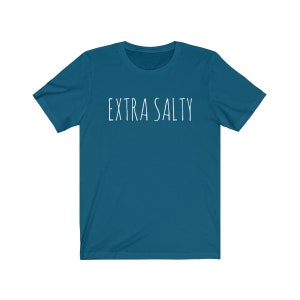 May include: A teal blue t-shirt with the text "EXTRA SALTY" printed in white on the front.