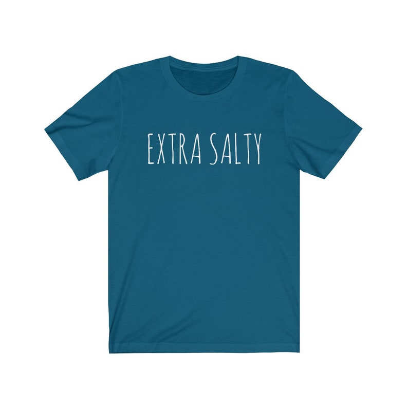 May include: A teal blue t-shirt with the text "EXTRA SALTY" printed in white on the front.