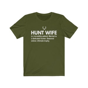 May include: A green t-shirt with a white print that reads "HUNT WIFE (n.) Incredibly patient; Married to a dedicated hunter; Seasonal widow; Ultimate trophy."
