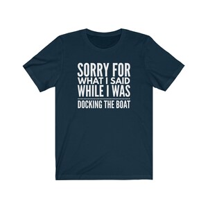 Op de afbeelding: Marineblauw T-shirt met de witte tekst "SORRY FOR WHAT I SAID WHILE I WAS DOCKING THE BOAT". Het shirt heeft korte mouwen en een ronde hals.