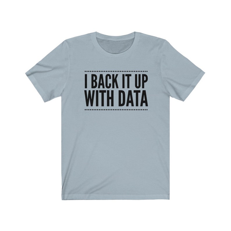 May include: A light blue short-sleeve t-shirt featuring the black text I BACK IT UP WITH DATA centered on the chest. The text is enclosed between two horizontal lines made of small black dots, creating a clean and simple graphic design.