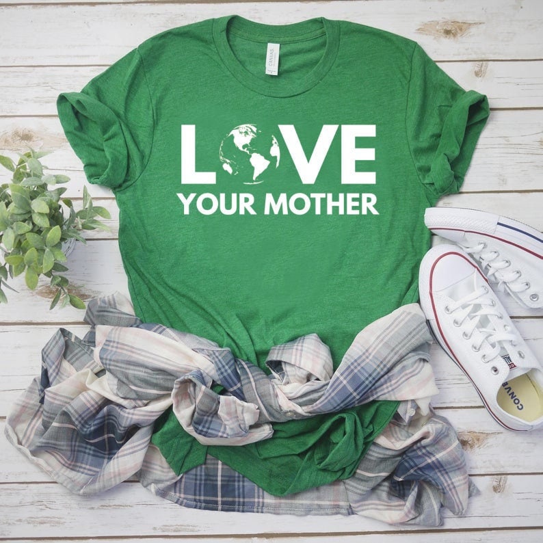 May include: Green t-shirt with white text that reads "LOVE YOUR MOTHER" and a graphic of the Earth.