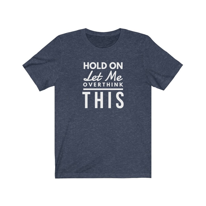 May include: A navy blue t-shirt with white text that reads "Hold On Let Me Overthink This".