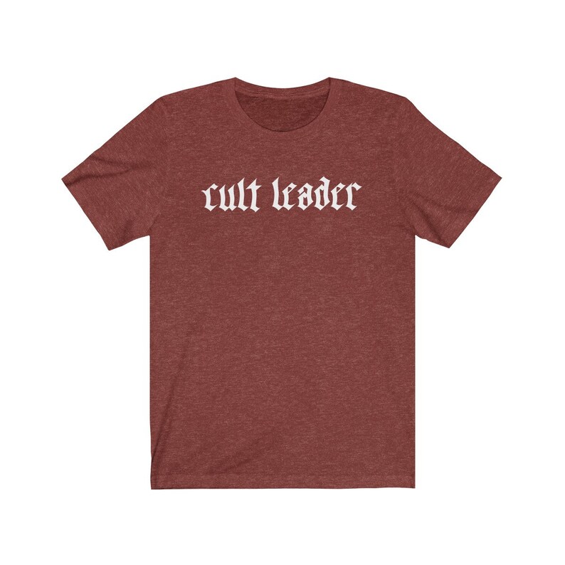 May include: A maroon t-shirt with the text "cult leader" in white gothic font.