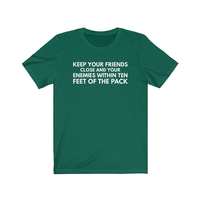 May include: A green t-shirt with the text "KEEP YOUR FRIENDS CLOSE AND YOUR ENEMIES WITHIN TEN FEET OF THE PACK" printed in white.