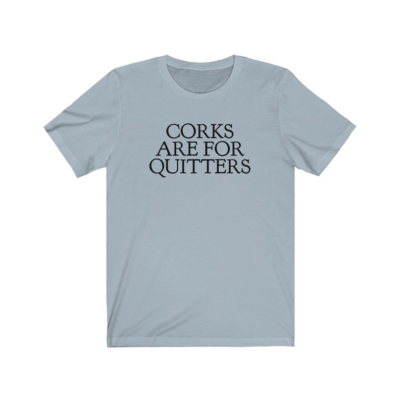 May include: A light blue t-shirt with the text "Corks Are For Quitters" printed in black.