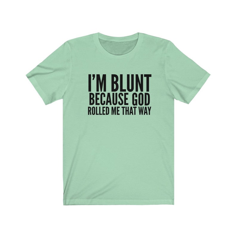 May include: A light green t-shirt with black text that reads "I'm blunt because God rolled me that way."