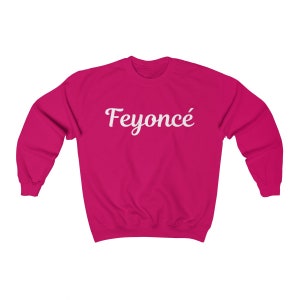 K&ouml;nnte beinhalten: Ein rosa Sweatshirt mit dem Text "Feyonc&eacute;" in wei&szlig;er kursivschrift.