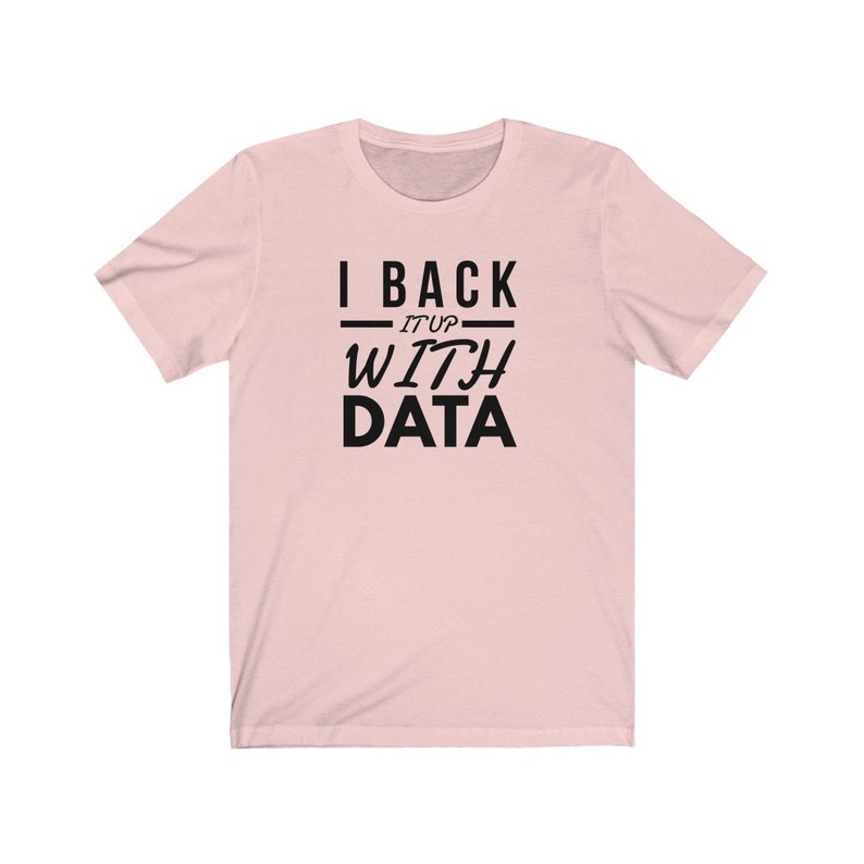 Puede incluir: Una camiseta de manga corta de color rosa claro con el texto impreso en negro I BACK IT UP WITH DATA. El dise&ntilde;o incluye l&iacute;neas horizontales a los lados de la palabra IT UP, con la palabra DATA en una fuente sans-serif m&aacute;s grande y negrita.