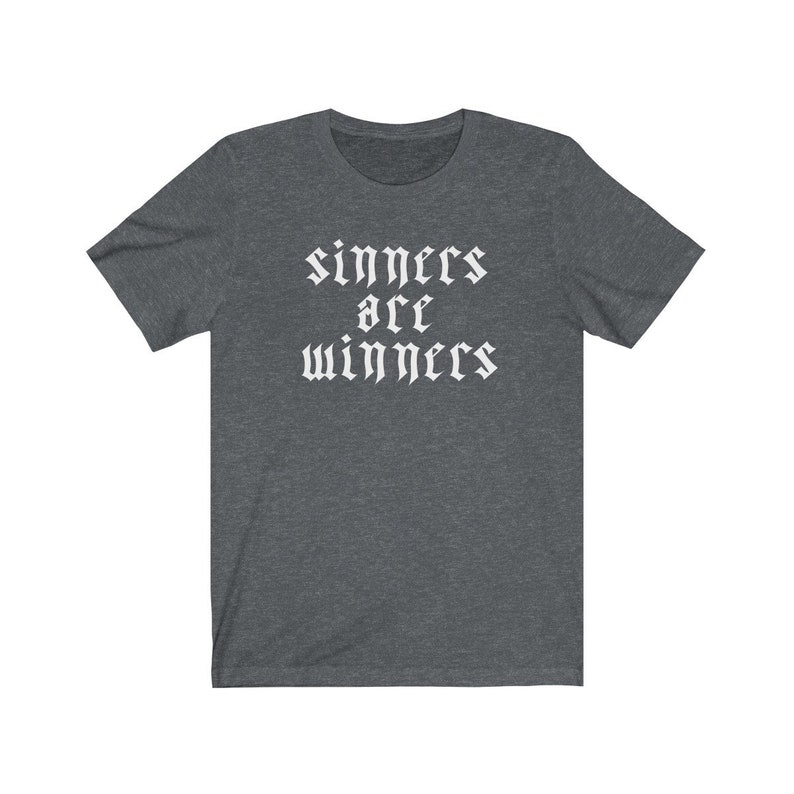 May include: A dark heather grey t-shirt with the text "sinners are winners" printed in white in a gothic font.