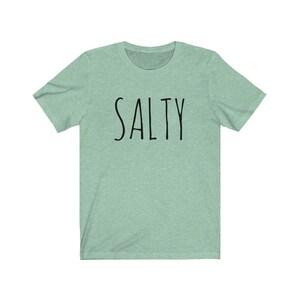 May include: A light green t-shirt with the word "SALTY" printed in black on the front.