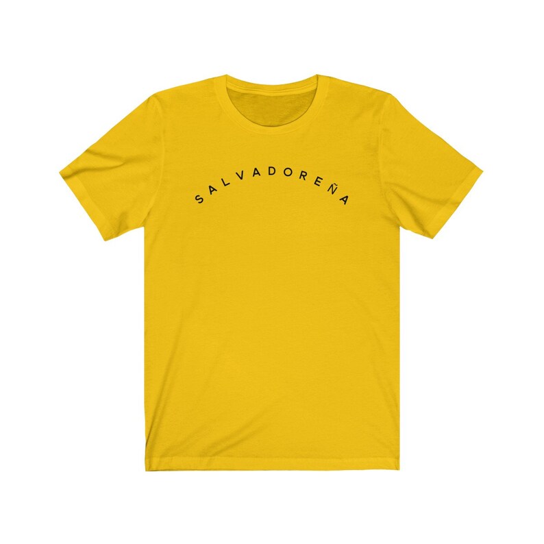 May include: A yellow t-shirt with black text that reads "SALVADORENA" in an arc.