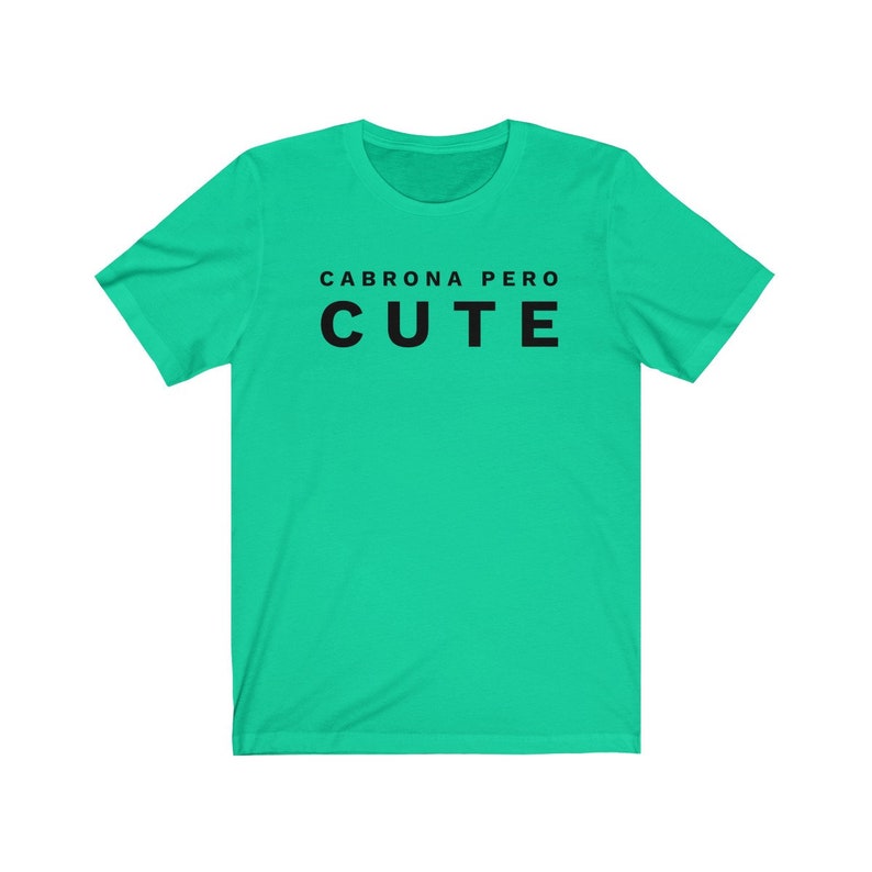 May include: A turquoise t-shirt with the text "Cabrona Pero Cute" printed in black.