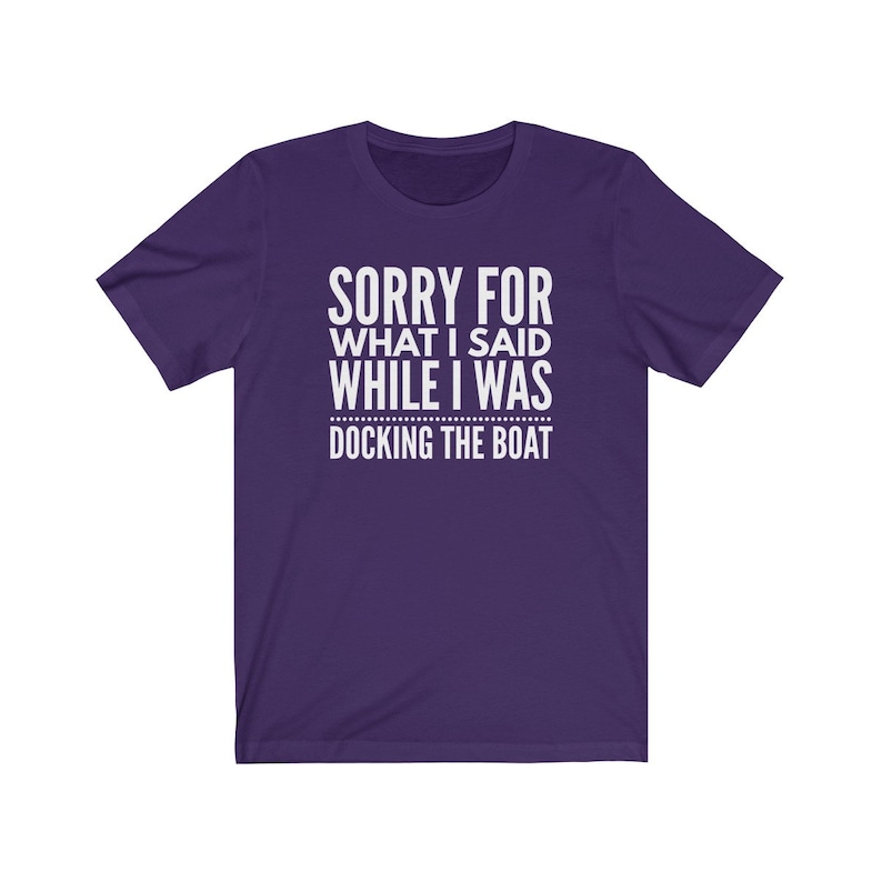 Op de afbeelding: Een paars t-shirt met de witte tekst "SORRY FOR WHAT I SAID WHILE I WAS DOCKING THE BOAT". Het shirt heeft korte mouwen en een ronde hals.
