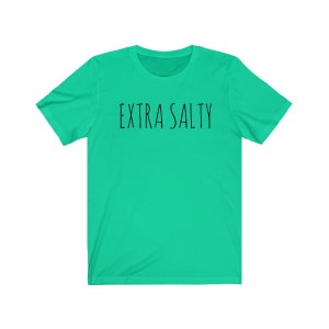 May include: A turquoise t-shirt with the text "EXTRA SALTY" printed in black.