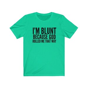 May include: A turquoise t-shirt with black text that reads "I'm blunt because God rolled me that way."