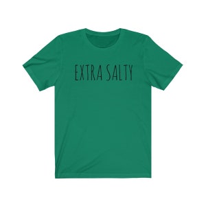May include: A green short-sleeved t-shirt with the text "EXTRA SALTY" printed in black on the front.