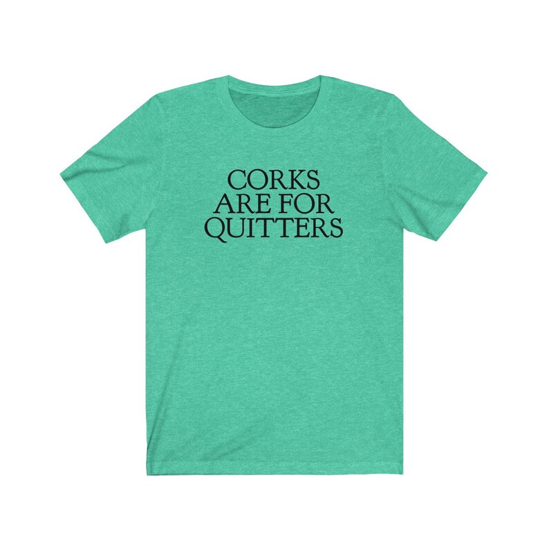 May include: A teal green t-shirt with the text "Corks Are For Quitters" printed in black.