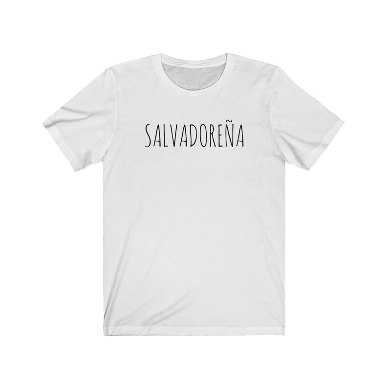 以下が含まれることがあります： 黒い文字で「SALVADORE&Ntilde;A」と書かれた白いTシャツです。