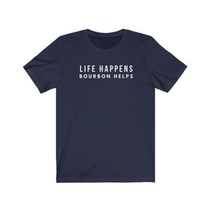 May include: A navy blue t-shirt with the text "LIFE HAPPENS BOURBON HELPS" printed in white on the front.