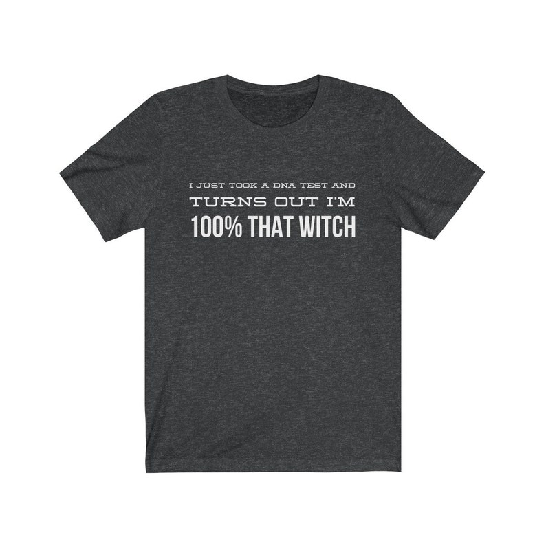 May include: A dark heather gray short-sleeve t-shirt with white text printed on the chest that reads: I JUST TOOK A DNA TEST AND TURNS OUT I'M 100% THAT WITCH. The shirt features a crew neckline and a standard fit with a simple, clean design.