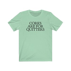May include: A light green t-shirt with the text "CORK ARE FOR QUITTERS" printed in black.
