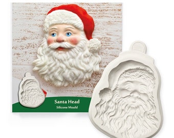 May include: White silicone mould for baking a Santa Claus head. The mould is shaped like a Santa head with a red hat and white beard. The text "Santa Head Silicone Mould" is printed on the packaging.