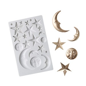 May include: A white silicone mould with multiple star and crescent moon shapes. The mould is used to create decorative cake toppers or other edible decorations.  There are also several gold-coloured star and crescent moon shapes next to the mould.