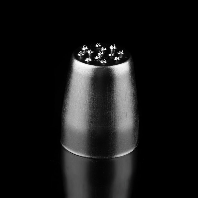 May include: A silver metal piping tip with a round base and a top with multiple small, pointed tips.