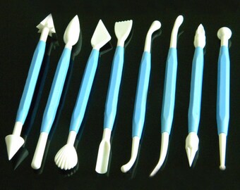 May include: Set of ten blue and white plastic tools for sculpting and decorating fondant or gum paste. The tools have various shapes, including a leaf, a flower, a shell, and a ball.