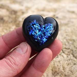 May include: A black glass heart with a blue iridescent glitter design inside.