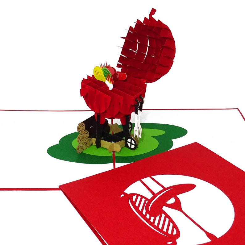 Puede incluir: Una tarjeta pop-up 3D roja y blanca que representa una barbacoa con la tapa abierta y comida cocin&aacute;ndose en su interior. La tarjeta est&aacute; cerrada y muestra una silueta roja de una barbacoa con una sola salchicha a la parrilla.