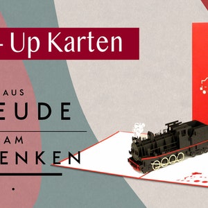 Puede incluir: Una tarjeta roja pop-up con un modelo 3D negro de un tren. La tarjeta est&aacute; abierta y el tren est&aacute; saliendo. La parte delantera de la tarjeta tiene una silueta blanca de un tren. El texto en la tarjeta dice "Pop-Up Karten aus Freude am Schenken".