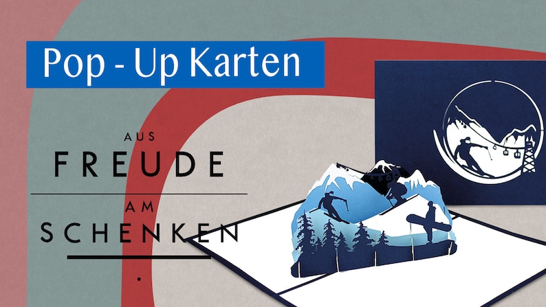 May include: A blue and white pop-up card with a winter mountain scene. The card is open and the pop-up features a mountain range with skiers and a ski lift. The card is from the company 'Freude am Schenken' and the text 'Pop-Up Karten' is at the top of the card.