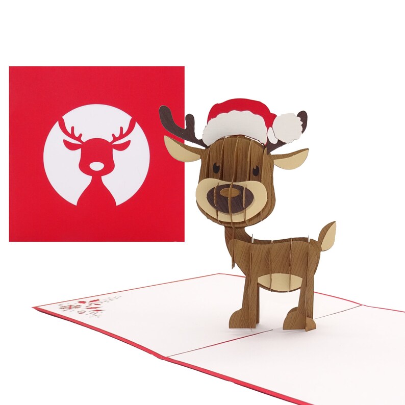 May include: A 3D pop-up Christmas card featuring a reindeer wearing a red Santa hat. The card is closed and the reindeer is standing on the card's interior. The card's exterior is red with a white silhouette of a reindeer.