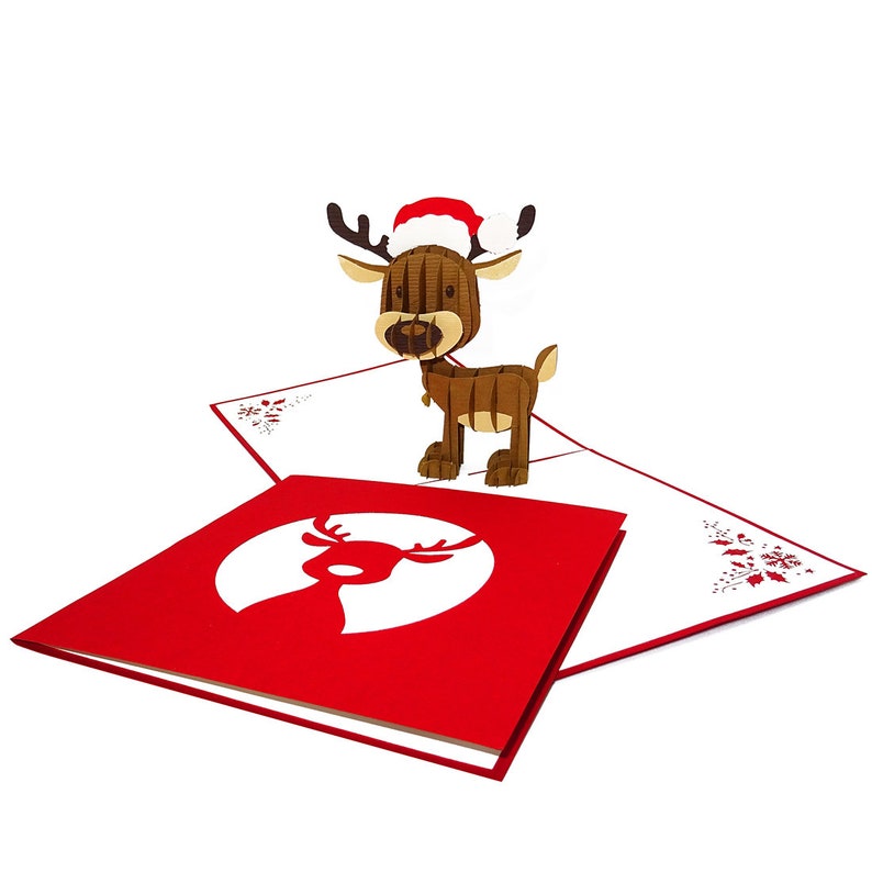 May include: A 3D pop-up card featuring a reindeer wearing a Santa hat. The card is red with a white reindeer silhouette.