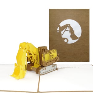 Puede incluir: Una tarjeta emergente 3D con una excavadora amarilla y marr&oacute;n. La excavadora tiene una gran cuchara y orugas. Una tarjeta marr&oacute;n con una silueta blanca de excavadora est&aacute; en el fondo. La tarjeta est&aacute; sobre una superficie blanca.