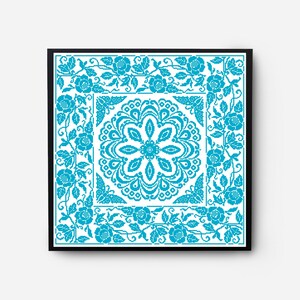 May include: A framed cross-stitch pattern with a blue floral design. The pattern features a central mandala with a repeating floral motif and a border of roses and vines.
