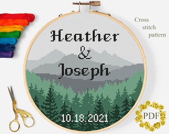 Puede incluir: Patrón de punto de cruz con un paisaje de montaña con un bosque en primer plano. El texto "Heather & Joseph 10.18.2021" está bordado en negro sobre el patrón.