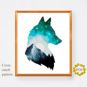 May include: A cross stitch pattern featuring a wolf silhouette with a mountain and starry sky inside. The wolf is outlined in black and the sky is a gradient of blue and green.