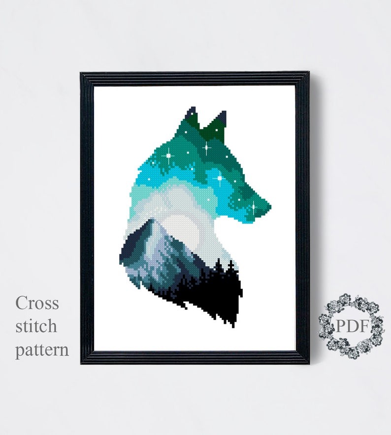 May include: Cross stitch pattern of a wolf silhouette with a mountain and starry night sky inside. The wolf is facing right and the colors are blue, green, and gray.