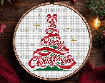 May include: A cross-stitch embroidery hoop featuring a Christmas tree design. The tree is formed with red ribbon-like elements and the words "Merry Christmas" in red. Gold star accents and a green base complete the festive design.