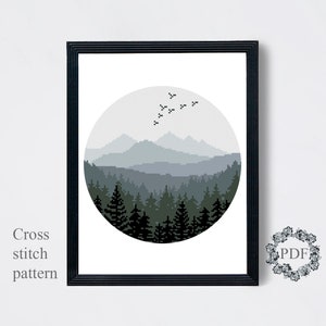 Peut inclure: Un motif de point de croix noir et blanc d'une for&ecirc;t et de montagnes dans un cercle. Les montagnes sont &agrave; l'arri&egrave;re-plan et la for&ecirc;t au premier plan. Il y a des oiseaux qui volent dans le ciel au-dessus des montagnes.