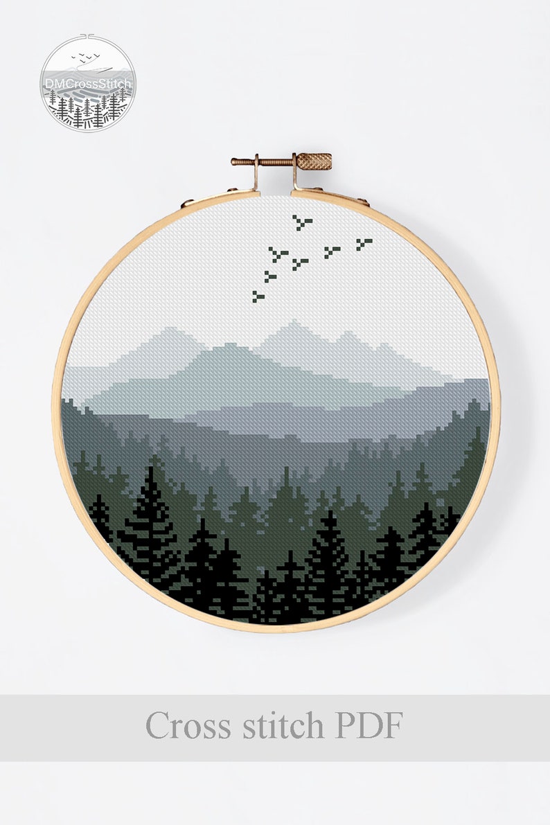 Peut inclure: Motif de point de croix repr&eacute;sentant une sc&egrave;ne de for&ecirc;t avec des montagnes en arri&egrave;re-plan. Les montagnes sont un d&eacute;grad&eacute; de bleu et de gris, et la for&ecirc;t est un d&eacute;grad&eacute; de vert et de noir. Il y a des oiseaux qui volent dans le ciel.