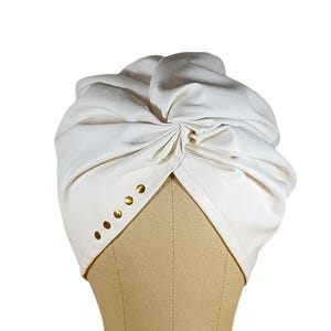 Turbante de couro sintético creme feito à mão: design elegante com cruz cravejada