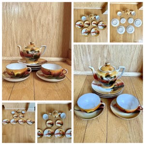 May include: A vintage tea set with a landscape design. The set includes a teapot, teacups, and saucers. The teacups and teapot have a landscape scene with a windmill. The set is in shades of orange, brown, and yellow.
