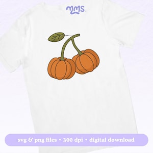 May include: White t-shirt featuring a cartoon illustration of two orange pumpkins connected by a green stem and leaf. The shirt has the text "svg & png files &bull; 300 dpi &bull; digital download" in a purple banner.